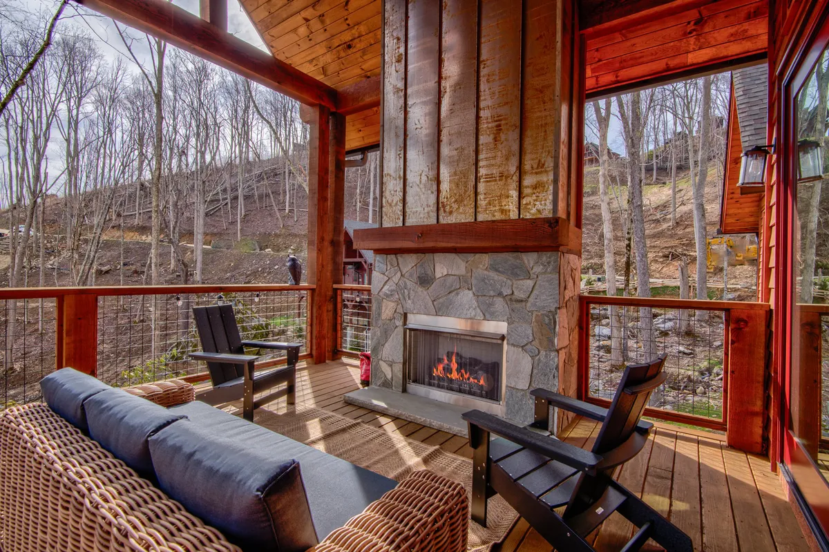 A warm, welcoming interior with a fireplace and comfortable seating, offering views of the outdoors through tall windows. The setting suggests a cozy space to unwind after a day of adventure, with natural light connecting the interior to the surrounding landscape.